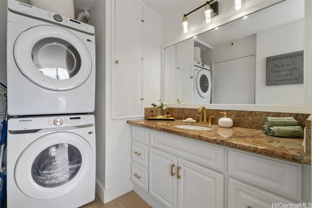 washroom featuring stacked washer / dryer and sink