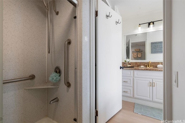 bathroom with vanity, walk in shower, and hardwood / wood-style floors