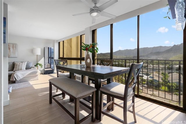 sunroom featuring a mountain view and ceiling fan