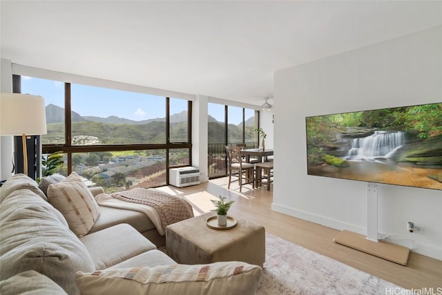 living room featuring light wood-type flooring, a wealth of natural light, and a wall of windows