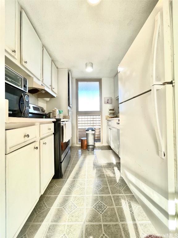 kitchen with white cabinetry, electric range, a textured ceiling, and white refrigerator