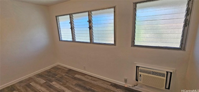 unfurnished room featuring a wall unit AC and dark hardwood / wood-style flooring