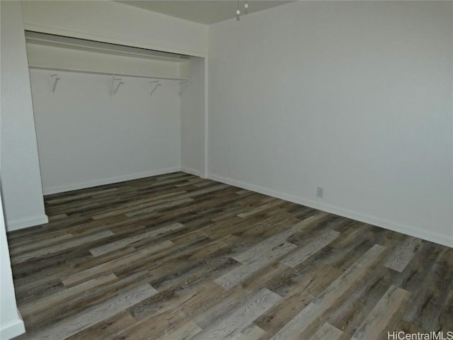 unfurnished bedroom with a closet and dark hardwood / wood-style floors