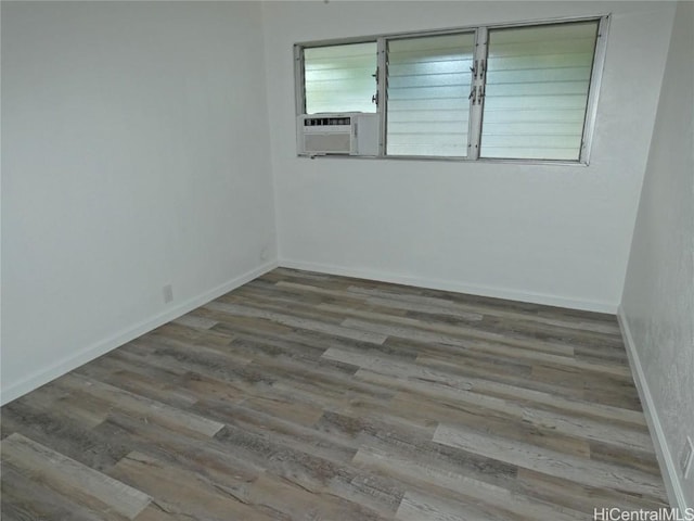 unfurnished room with cooling unit and wood-type flooring