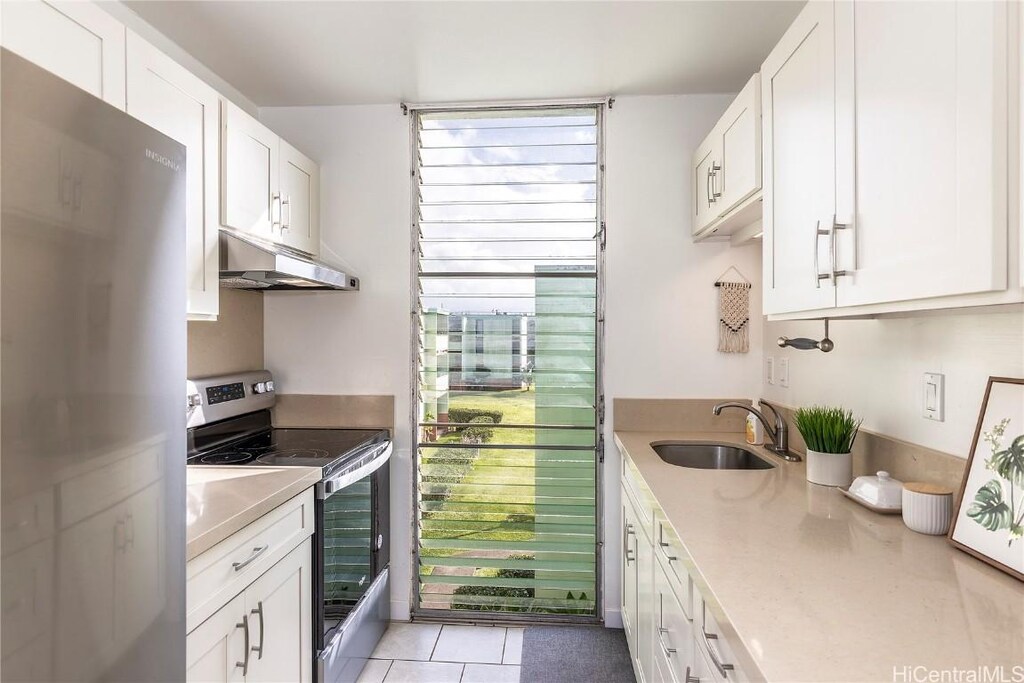 1045 Aheahe Ave Unit 318, Wahiawa, HI 96786 - kitchen with light countertops, appliances with stainless steel finishes, white cabinets, a sink, and under cabinet range hood
