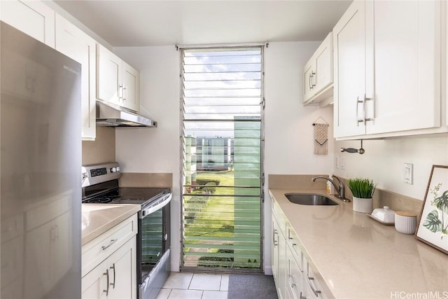 kitchen with light countertops, appliances with stainless steel finishes, white cabinets, a sink, and under cabinet range hood