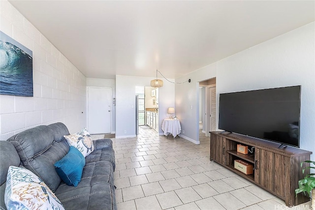 living area with light tile patterned floors and baseboards