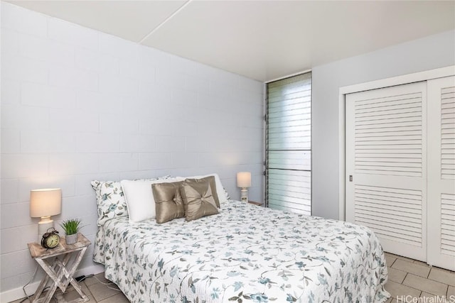 bedroom with light tile patterned floors and a closet