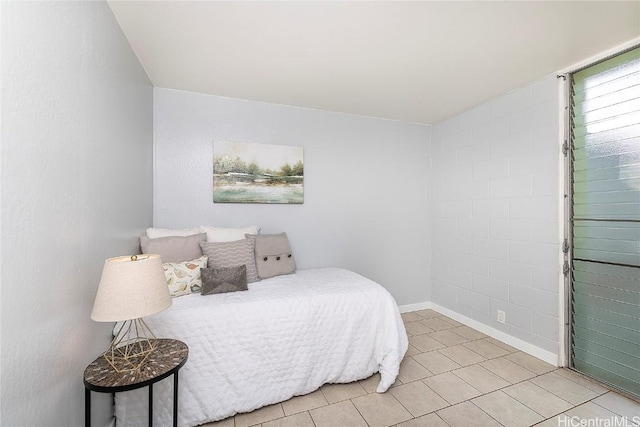 bedroom with light tile patterned floors and baseboards