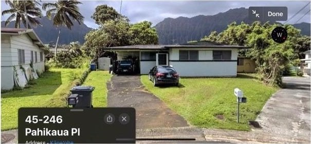 view of front of property with a mountain view and a front lawn