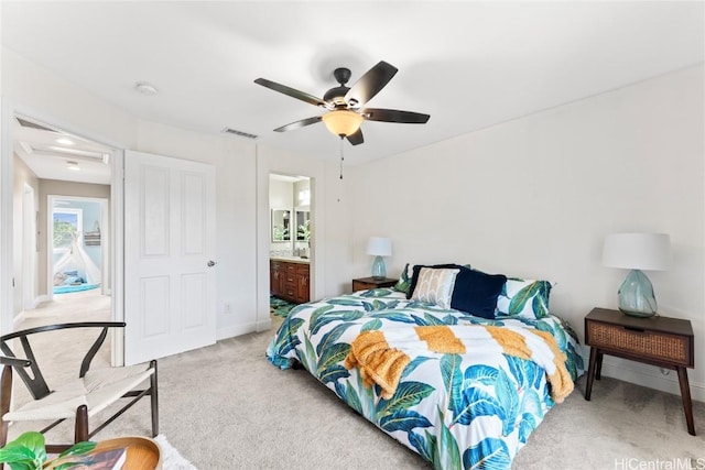 bedroom featuring visible vents, baseboards, light carpet, ensuite bath, and a ceiling fan