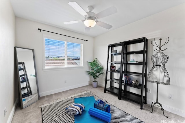 exercise room with baseboards, ceiling fan, and carpet flooring