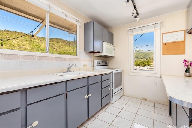 kitchen with sink, white appliances, gray cabinets, and light tile patterned floors