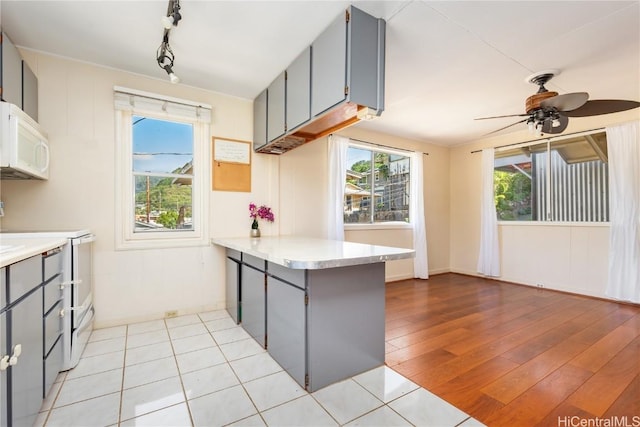 kitchen featuring range with electric cooktop, plenty of natural light, gray cabinets, and kitchen peninsula