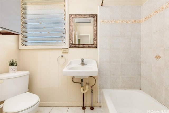 bathroom featuring tile patterned floors, toilet, a bathing tub, and sink