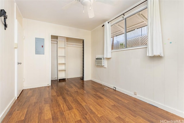 unfurnished bedroom featuring a closet, ceiling fan, electric panel, dark hardwood / wood-style flooring, and an AC wall unit