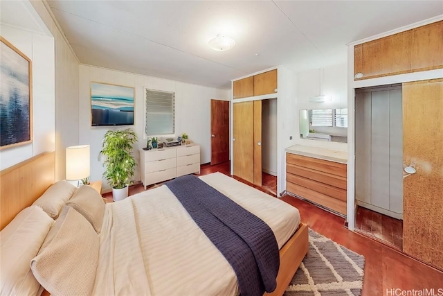 bedroom featuring dark wood finished floors and two closets