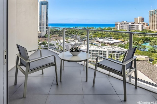 balcony with a water view and a view of city