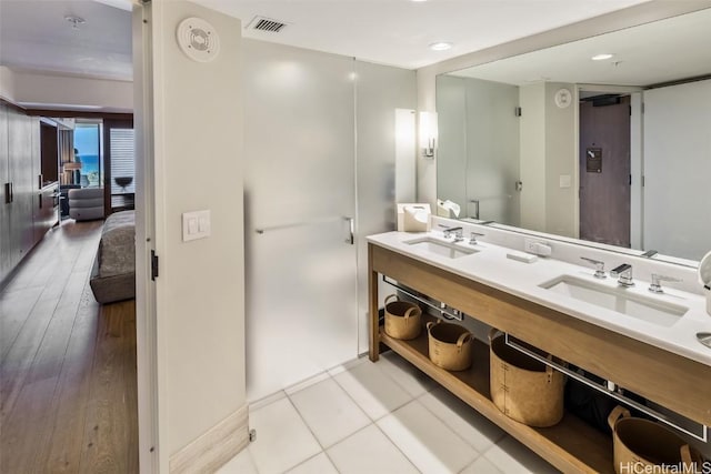 bathroom with tile patterned floors, visible vents, a sink, and double vanity