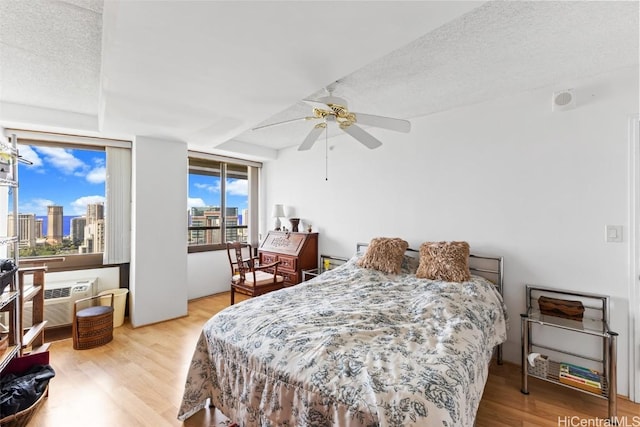 bedroom featuring ceiling fan, wood-type flooring, and a textured ceiling