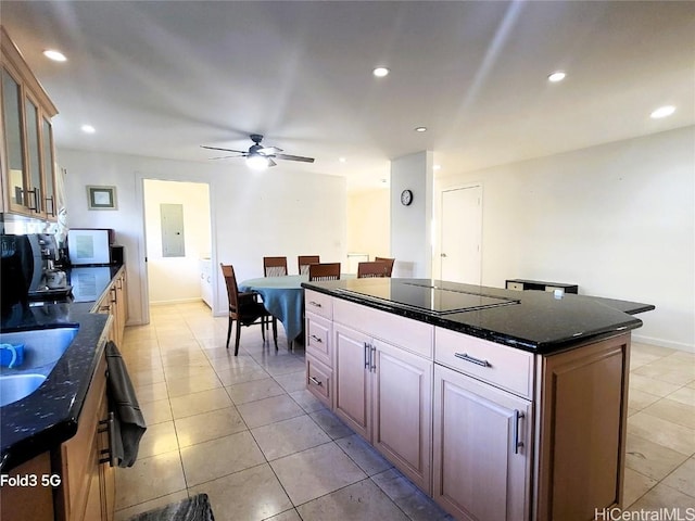 kitchen with a kitchen island, sink, black electric stovetop, light tile patterned floors, and ceiling fan