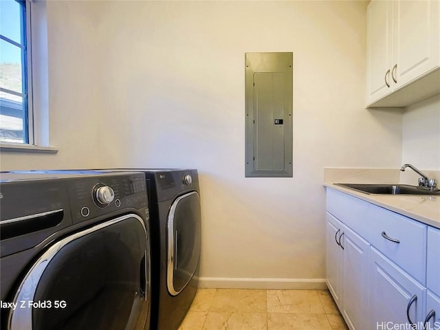 clothes washing area featuring cabinets, electric panel, sink, and washer and clothes dryer