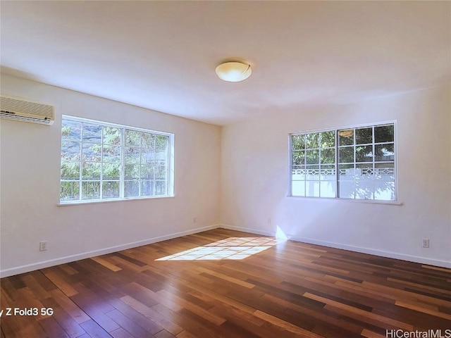 spare room with dark wood-type flooring and a wall mounted air conditioner