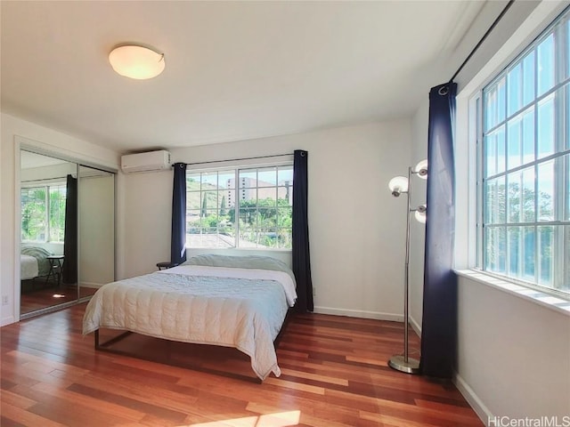 bedroom with wood-type flooring and a wall unit AC