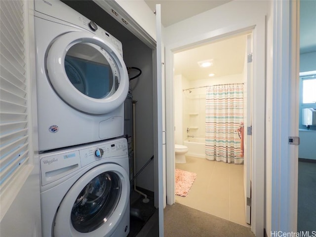 clothes washing area with stacked washing maching and dryer