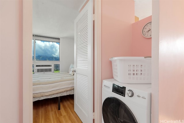 laundry area with wood finished floors, laundry area, washer / clothes dryer, and cooling unit