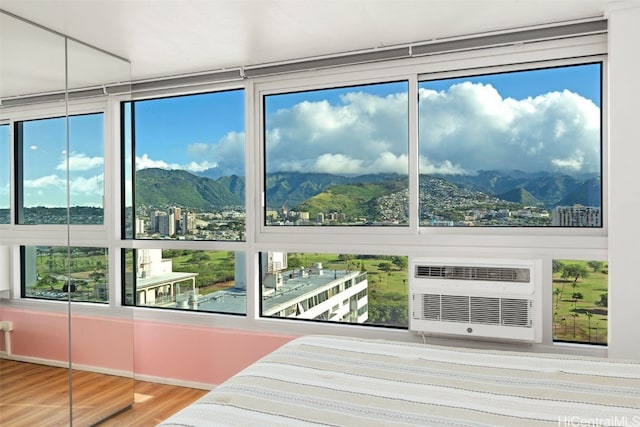 interior space featuring a view of city, an AC wall unit, and a mountain view