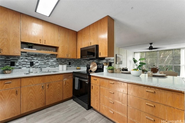 kitchen featuring black / electric stove, light hardwood / wood-style floors, sink, and tasteful backsplash