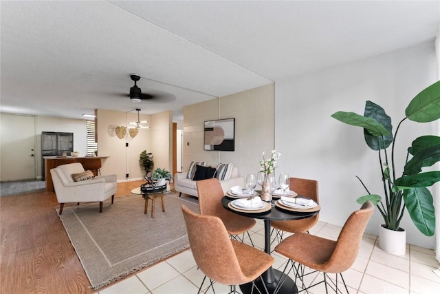 dining room with ceiling fan, a textured ceiling, and light wood-type flooring