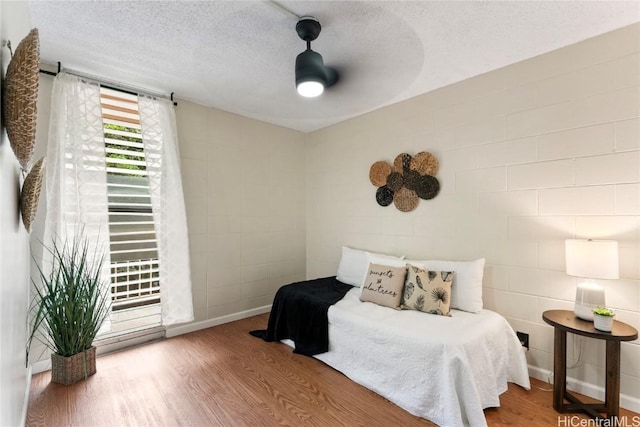 bedroom featuring hardwood / wood-style flooring and a textured ceiling