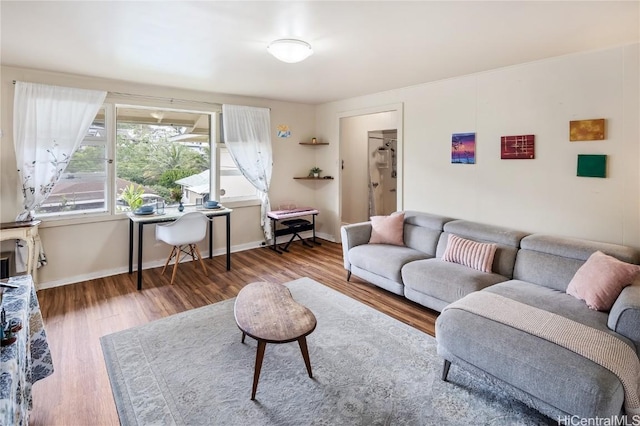 living area with baseboards and wood finished floors