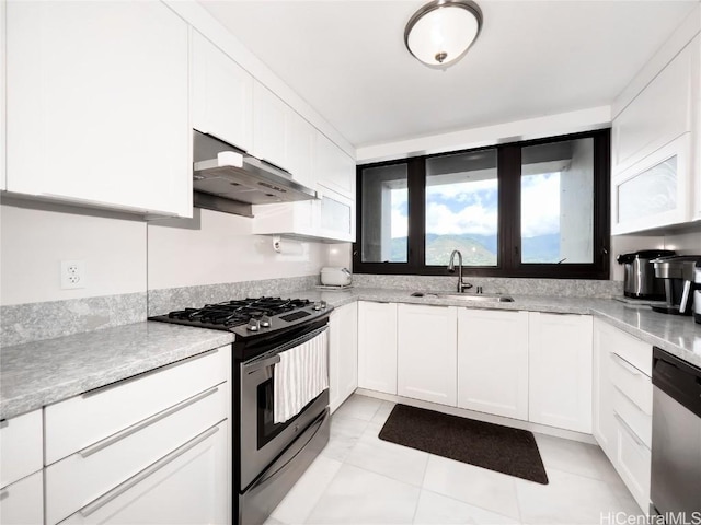 kitchen featuring sink, light tile patterned floors, stainless steel appliances, light stone countertops, and white cabinets