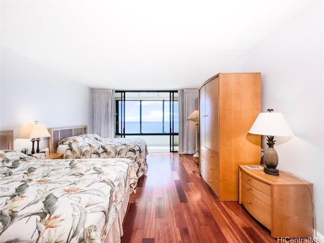 bedroom featuring dark wood-type flooring and expansive windows