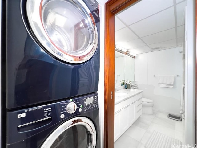 clothes washing area with stacked washer and dryer and sink