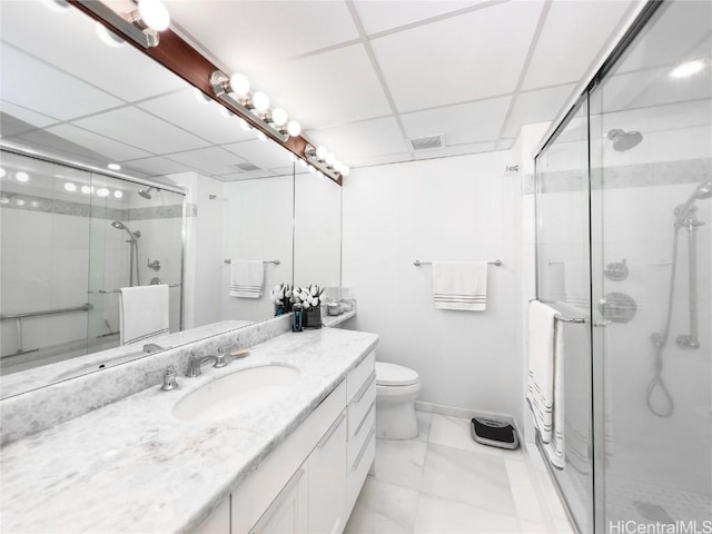 bathroom with vanity, a shower with door, and a drop ceiling