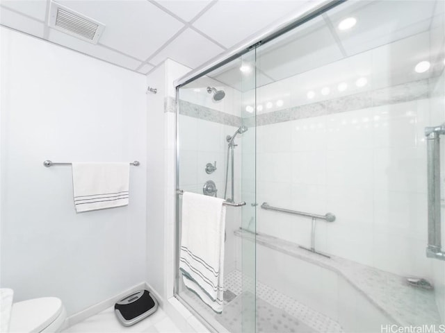 bathroom featuring toilet and a shower with shower door