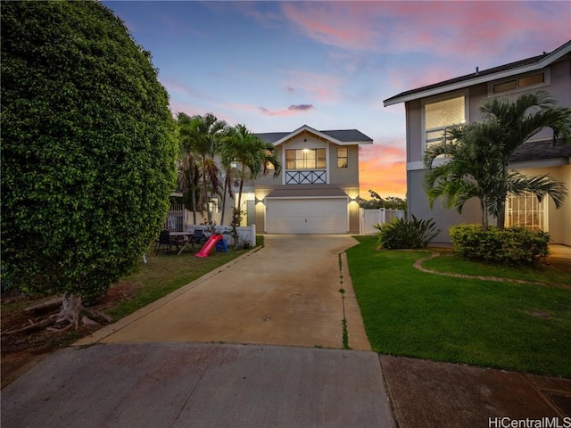 view of front of home with a garage and a lawn