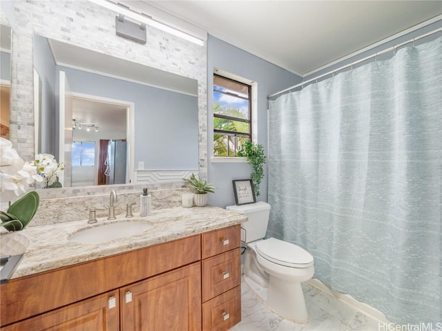 bathroom featuring vanity, crown molding, and toilet