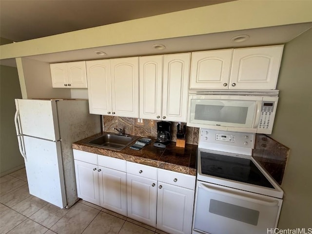 kitchen with tasteful backsplash, sink, white cabinets, and white appliances