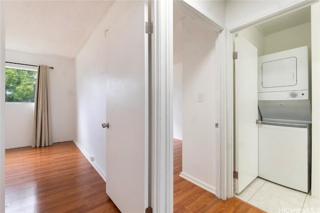 hall featuring light wood-type flooring and stacked washing maching and dryer