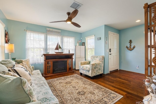 living room with dark wood-type flooring and ceiling fan