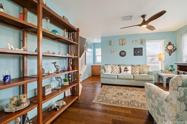 living room featuring ceiling fan and dark hardwood / wood-style floors