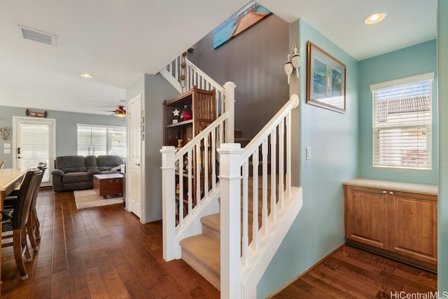 stairs featuring hardwood / wood-style flooring and ceiling fan