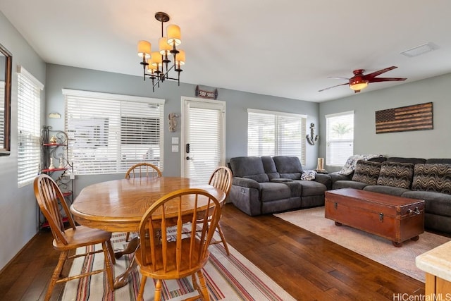 dining room featuring dark hardwood / wood-style flooring and ceiling fan with notable chandelier