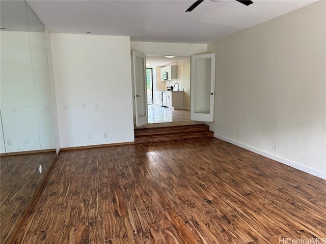 unfurnished room featuring sink, hardwood / wood-style flooring, and ceiling fan