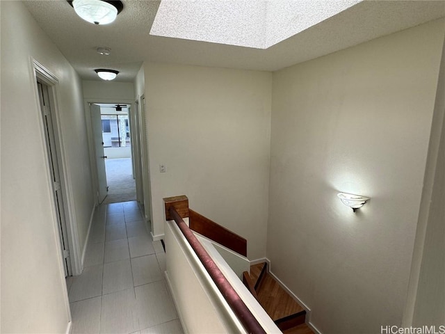 stairs with tile patterned floors and a textured ceiling